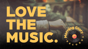 Reklamskylt med texten "Love the Music" och logotyp för Morning Glory Records. Man kan se händer från personer som väljer ut vinyler från en back.